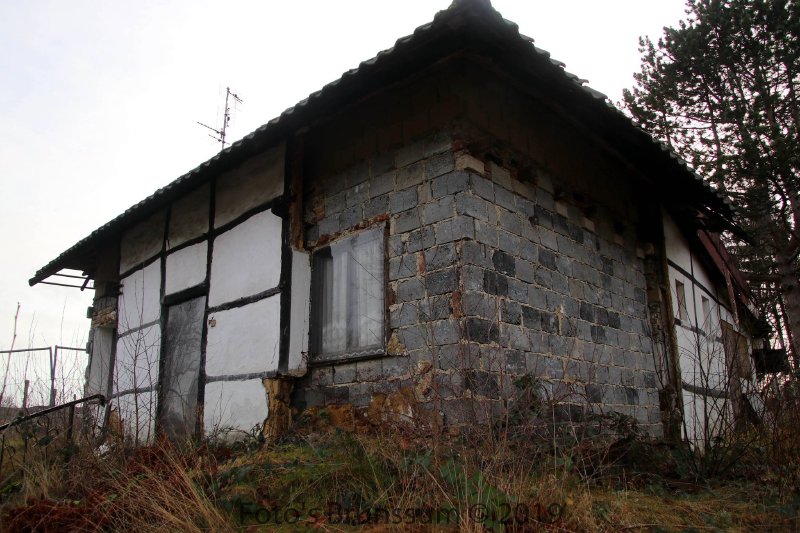 Rear of the cottage showing exposed stonework, 2019